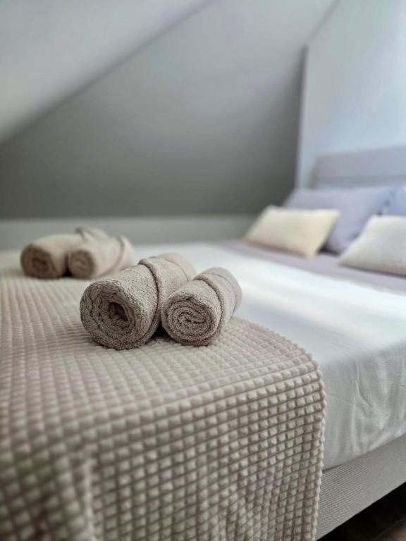 a bed with two rolled towels on top of it at Domus Viriato in Viseu