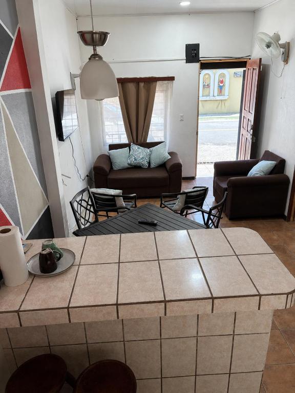 a living room with a couch and a table at Buganvilias Quepos No 1 con aire acondicionado in Quepos