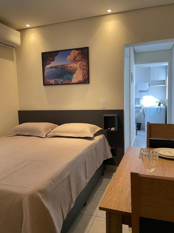 a bedroom with a bed and a table and a picture at Casa 24 m2 aconchegante com AC in Sorocaba