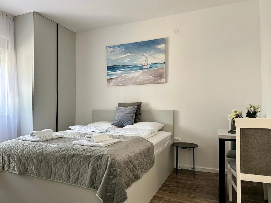 a bedroom with a bed and a painting on the wall at Milty Apartments in Novi Sad