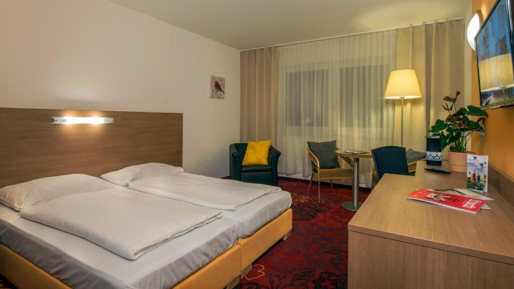 ein Hotelzimmer mit einem Bett und einem Schreibtisch in der Unterkunft Kaiserrast in Stockerau