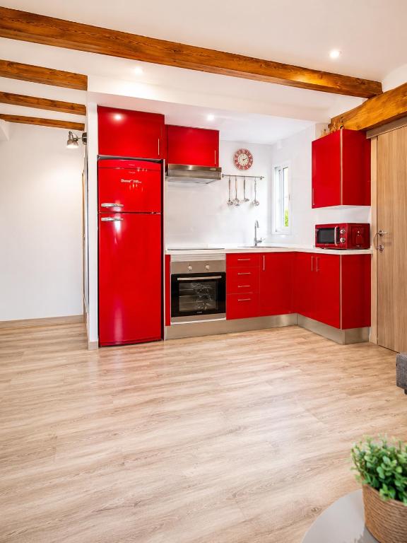 a red kitchen with red cabinets and wooden floors at apartamento las torres-botanico con 2 habitaciones in Valencia