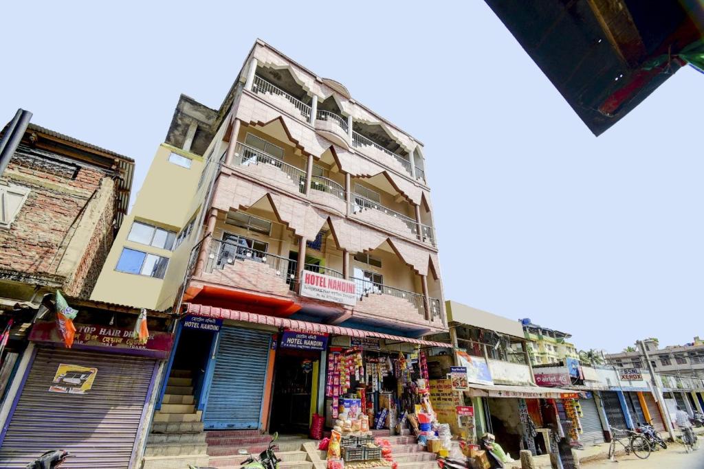a tall building with shops on a city street at Hotel O NANDINI in Dibrugarh