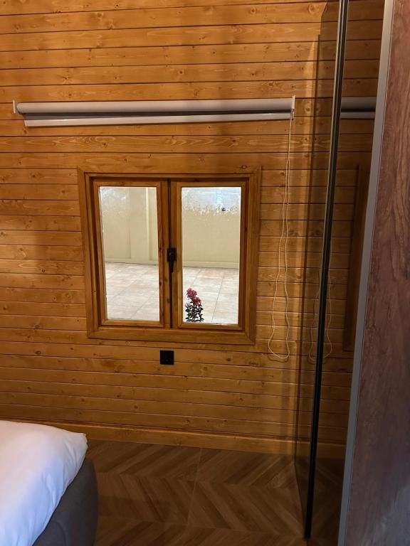 a bedroom with a window in a wooden wall at اكواخ سمر in Abha