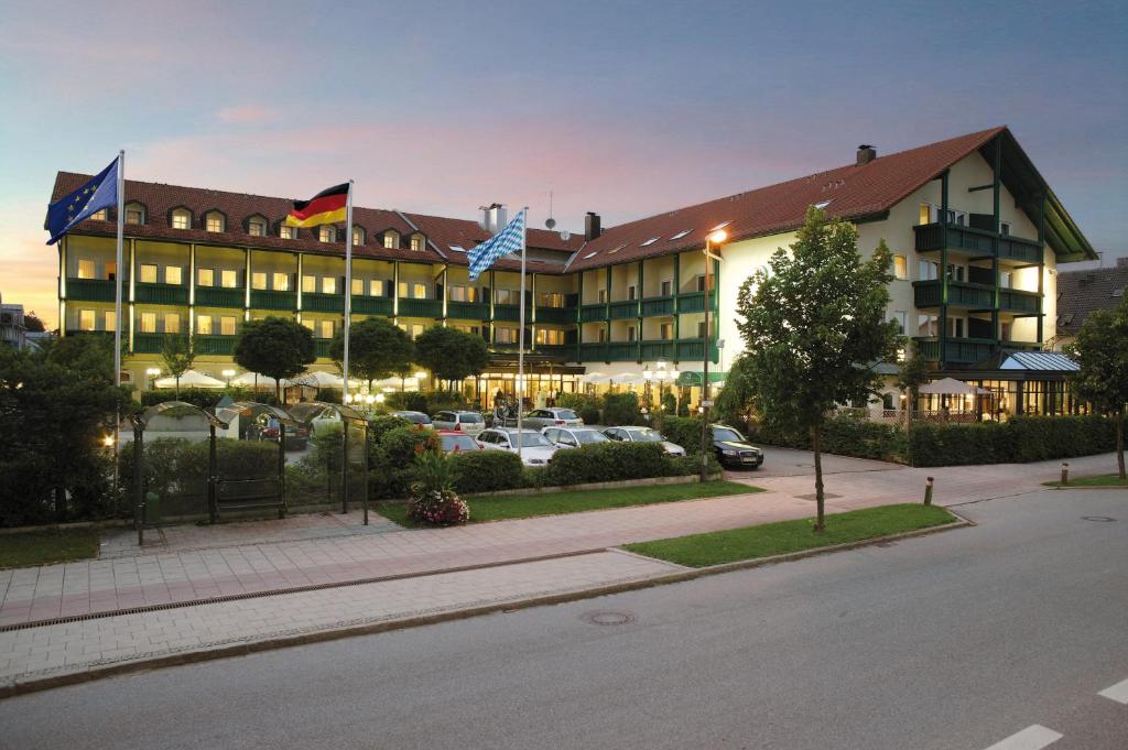 ein großes Gebäude mit Flaggen auf einem Parkplatz in der Unterkunft Bauer Hotel und Restaurant in Feldkirchen