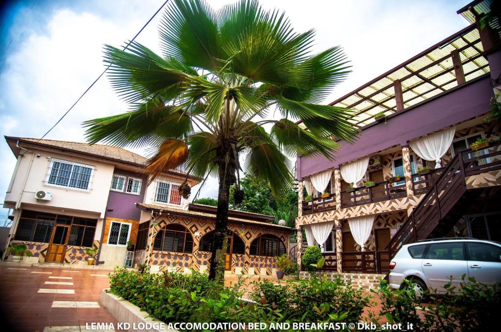 a palm tree in front of a building at Le Mia KD lodge in Sekondi-Takoradi