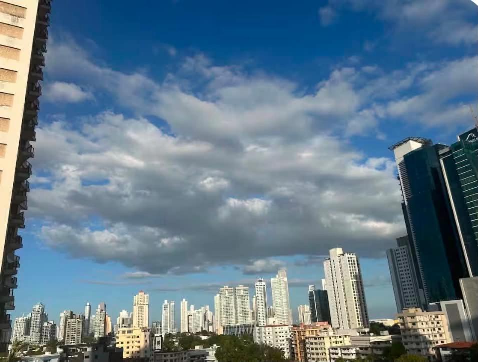 a city skyline with tall buildings and a cloudy sky at Airhome free shuttle in Panama City