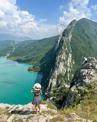 a woman is standing on top of a mountain at Hermes Luxury Suites in Gramsh