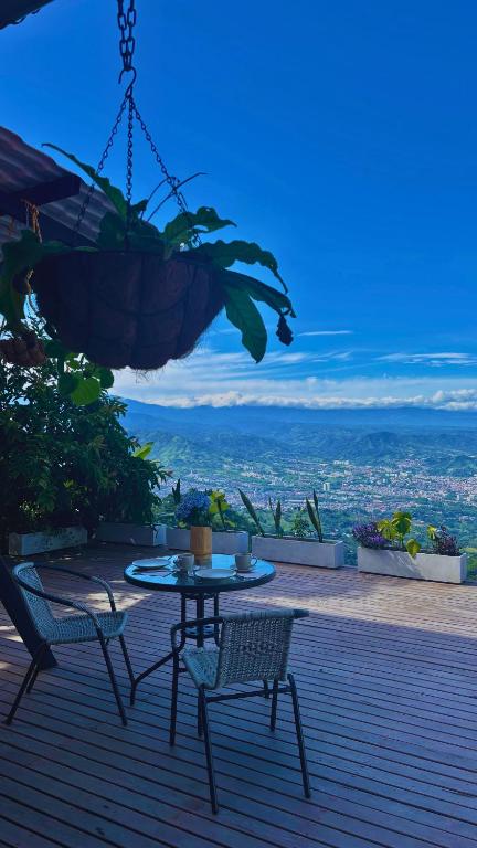 a table and chairs on a deck with a view at Casa Alta Colombia, ecolodge con vistas, Pereira in Dosquebradas