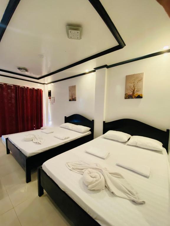 a room with two beds with towels on them at Strangers Inn&Bar in General Luna
