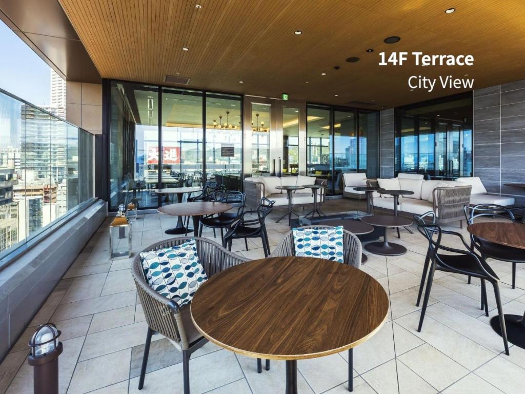 a restaurant with tables and chairs and a city view at Hotel Intergate Hiroshima in Hiroshima