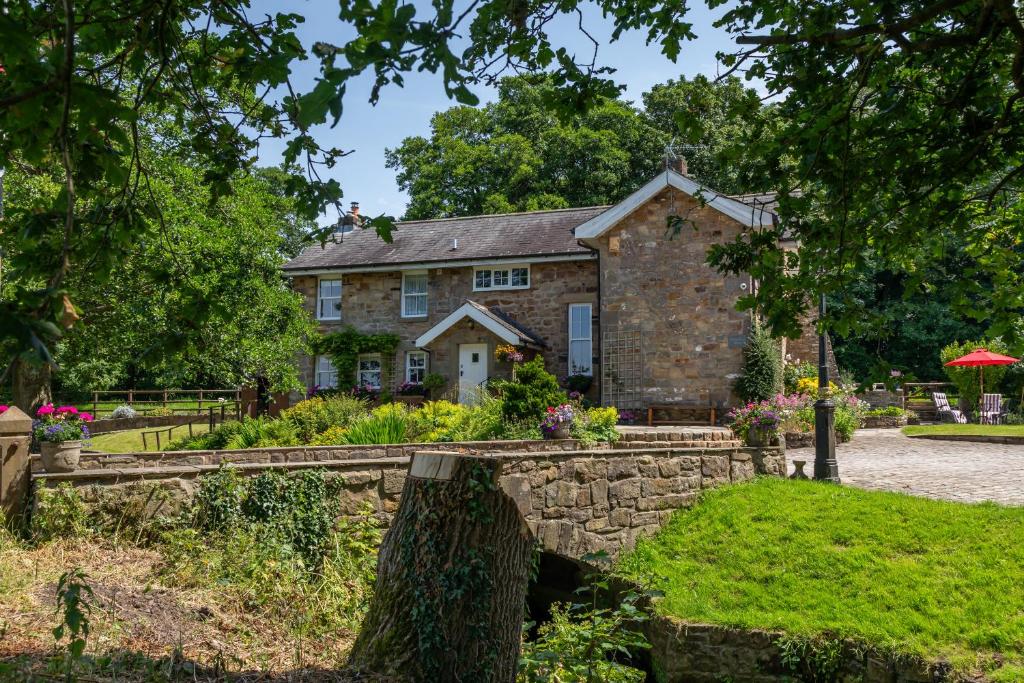 an old stone house with a stone wall at Picket Post House Accommodation in Catterall