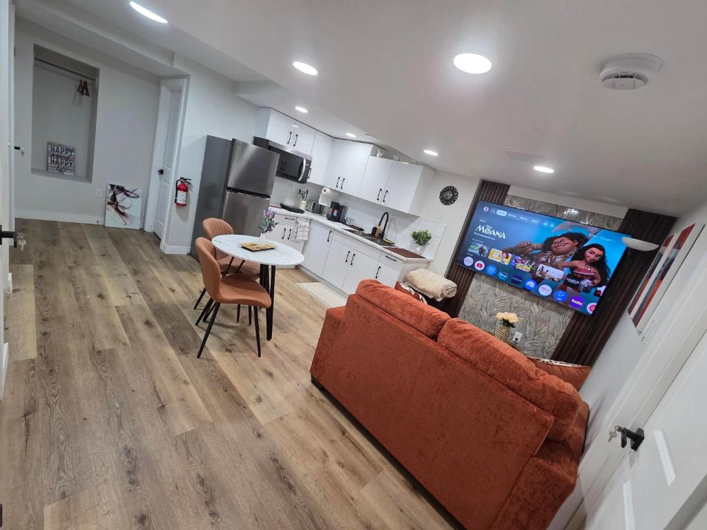a living room with a couch and a table and a kitchen at Ope suites Winnipeg in Winnipeg