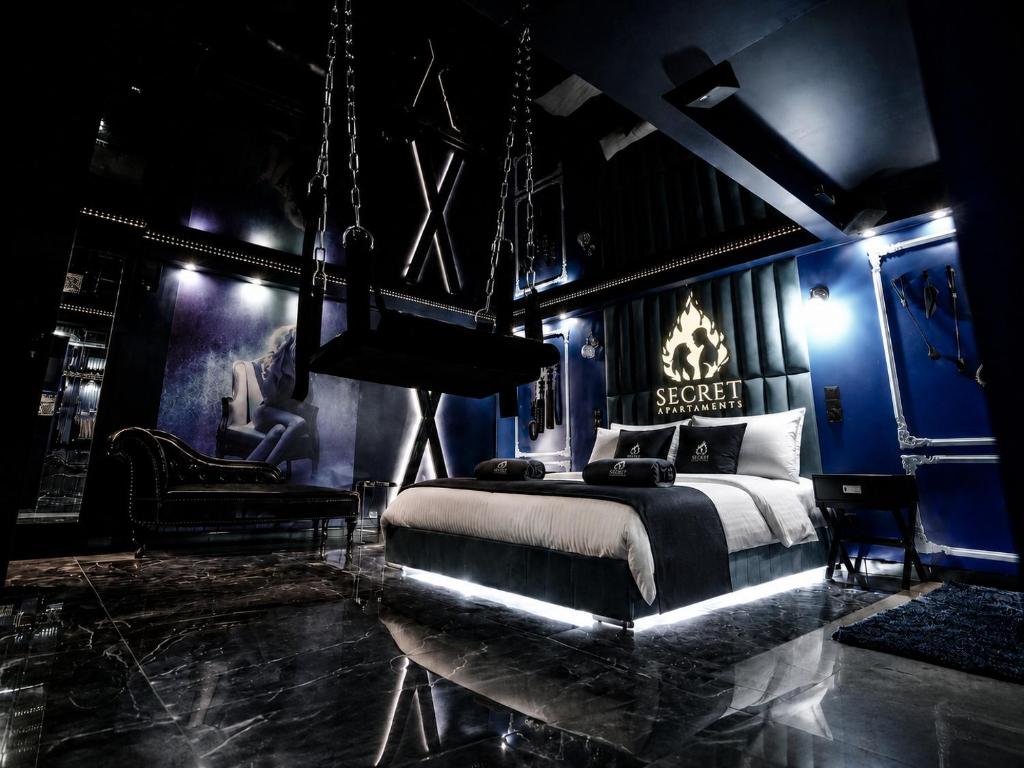 a bedroom with a king sized bed and blue walls at Grey Champagne Spa by Secret Apartament in Gdańsk