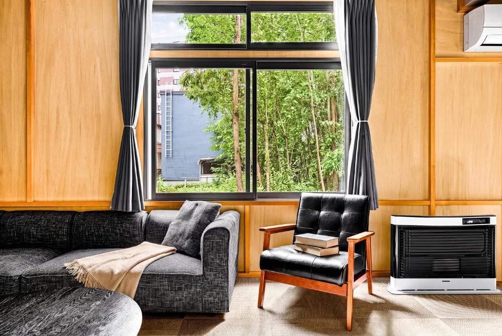 a living room with a couch and a chair and a window at THE GRANDEUR in Sapporo