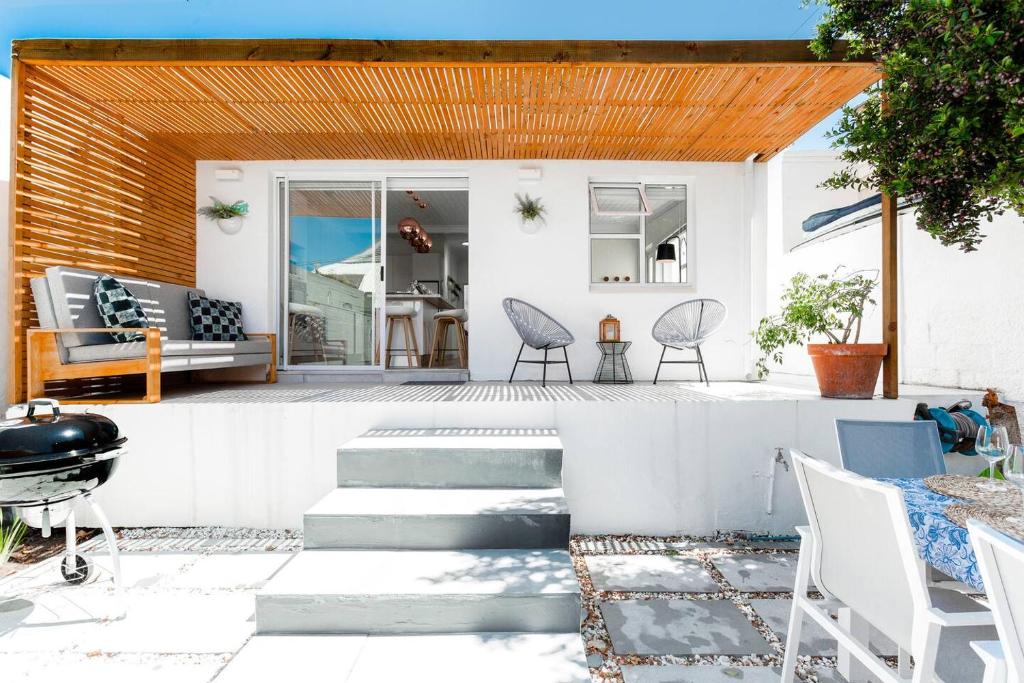 a patio with chairs and a table and a grill at Quiet Central Home Near Newlands Cricket in Cape Town