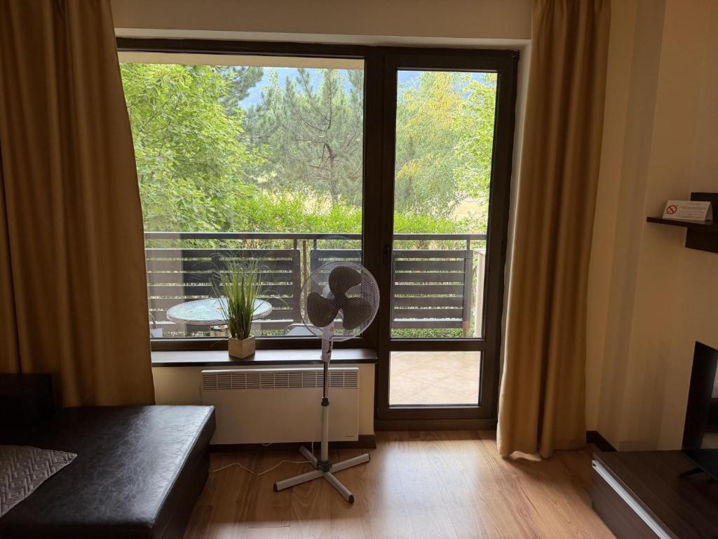 a living room with a large window and a fan at Pirin Getaway Heaven in Razlog