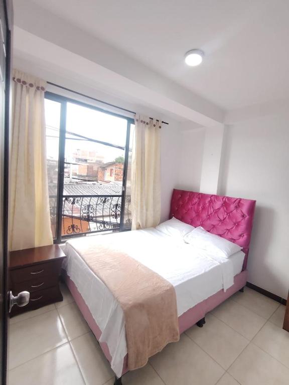 a bedroom with a bed with a large window at Apartamentos El paraiso cerca a Termales - cerca al centro - se aceptan mascotas in Santa Rosa de Cabal