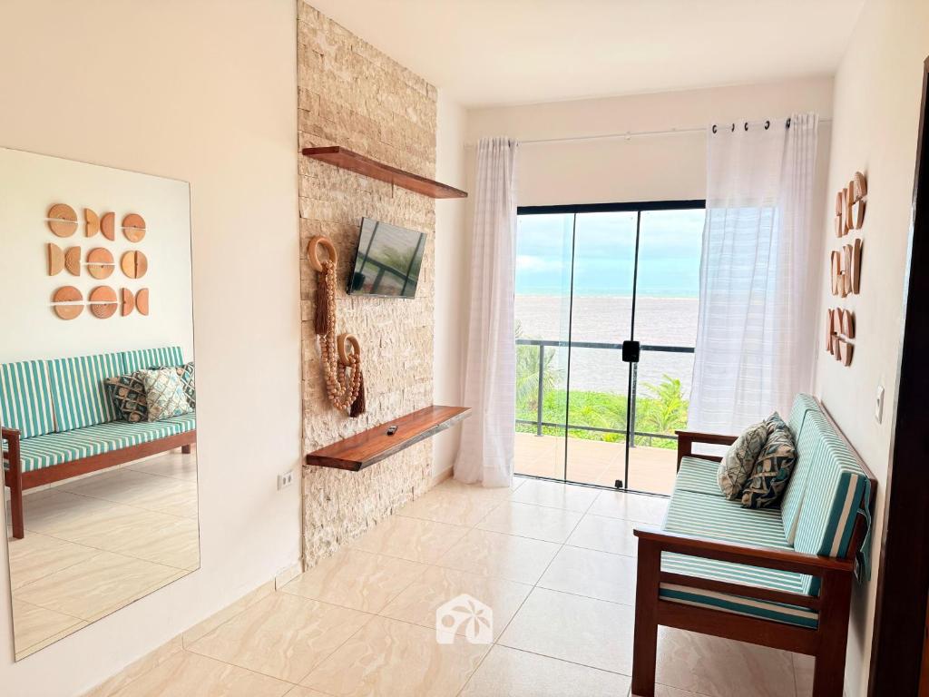 a living room with a view of the ocean at Roraimar Prime Maragogi - Beira Mar in Maragogi