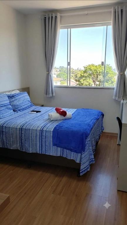 a bedroom with a bed and a large window at Edifício Paris 411 in Lagoa Santa