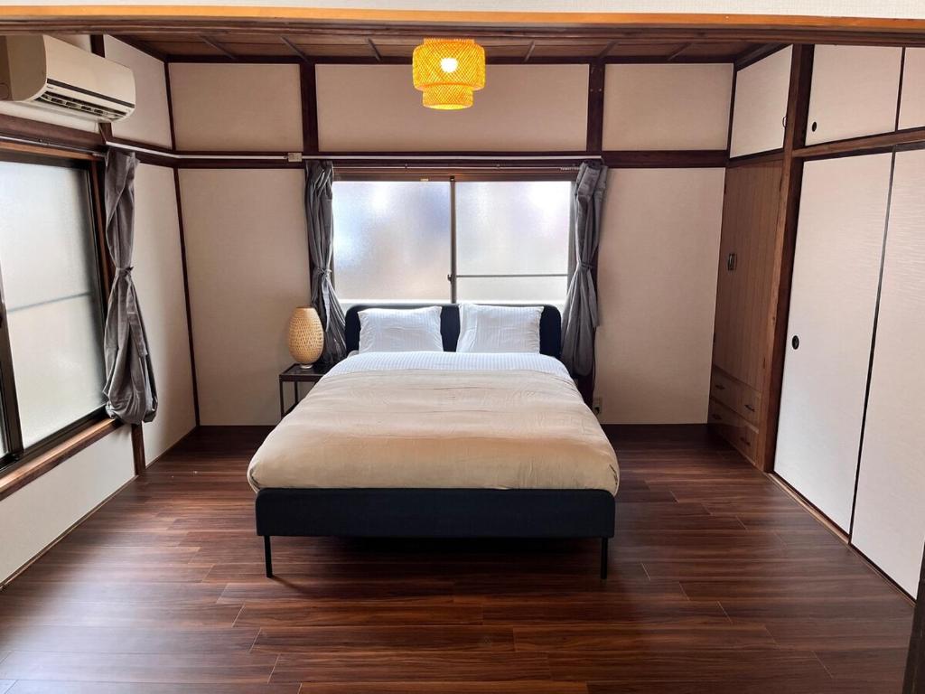 a bedroom with a bed in a room with windows at 御宿空蝉 in Tokyo