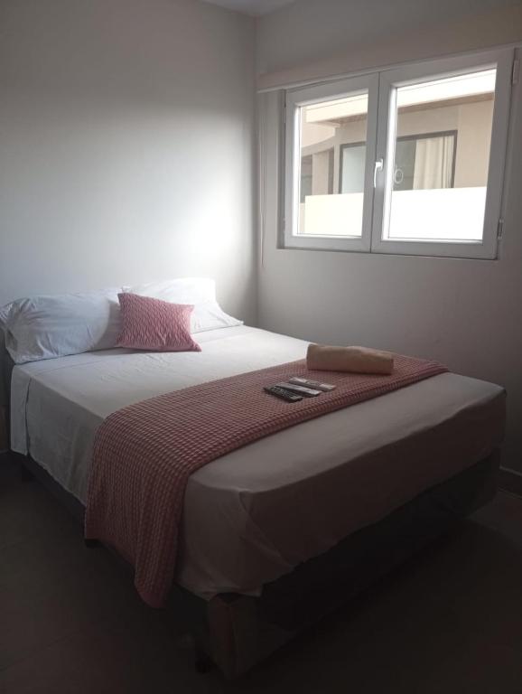a bedroom with a large bed with a window at JG Hotel in Santa Cruz de la Sierra