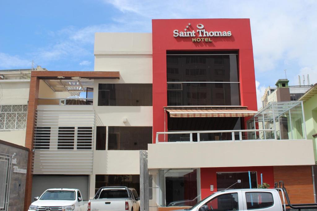 een gebouw waar auto's voor geparkeerd staan bij Hotel Saint Thomas in Quito