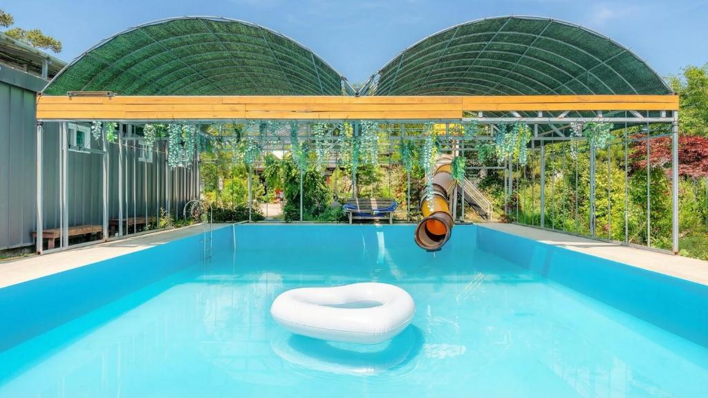 a swimming pool with a toilet in the water at gyeongju yongcheonsu caravan in Gyeongju