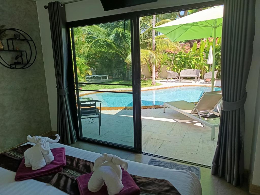 a bedroom with a bed and a view of a pool at Villa Paradise Island in Rawai Beach