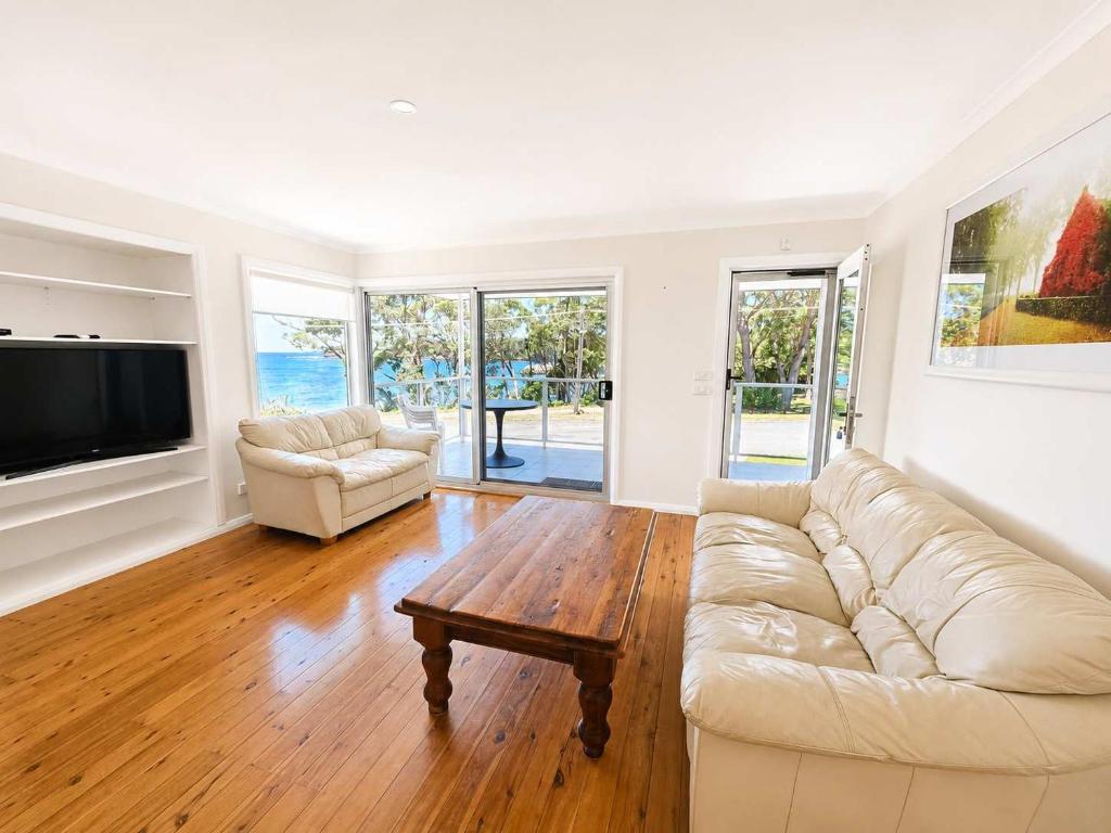 a living room with a couch and a coffee table at Harbour Haven - steps from Ulladulla Harbour in Ulladulla