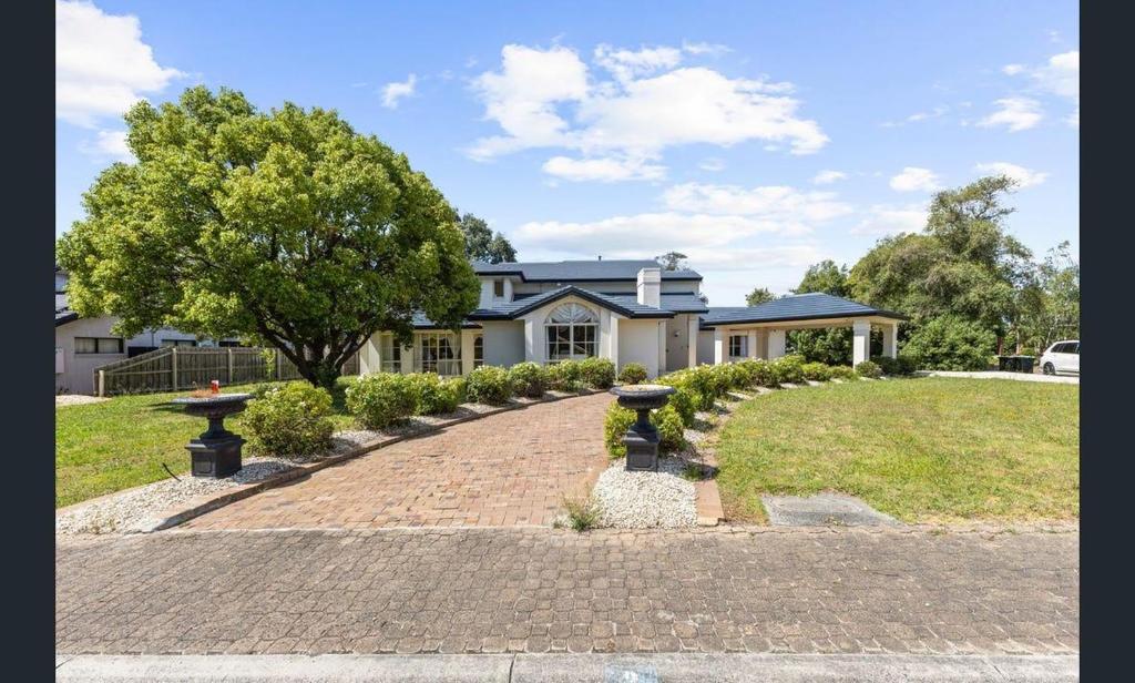 a house with a brick driveway in front of a house at Sarovar Holidays in Traralgon