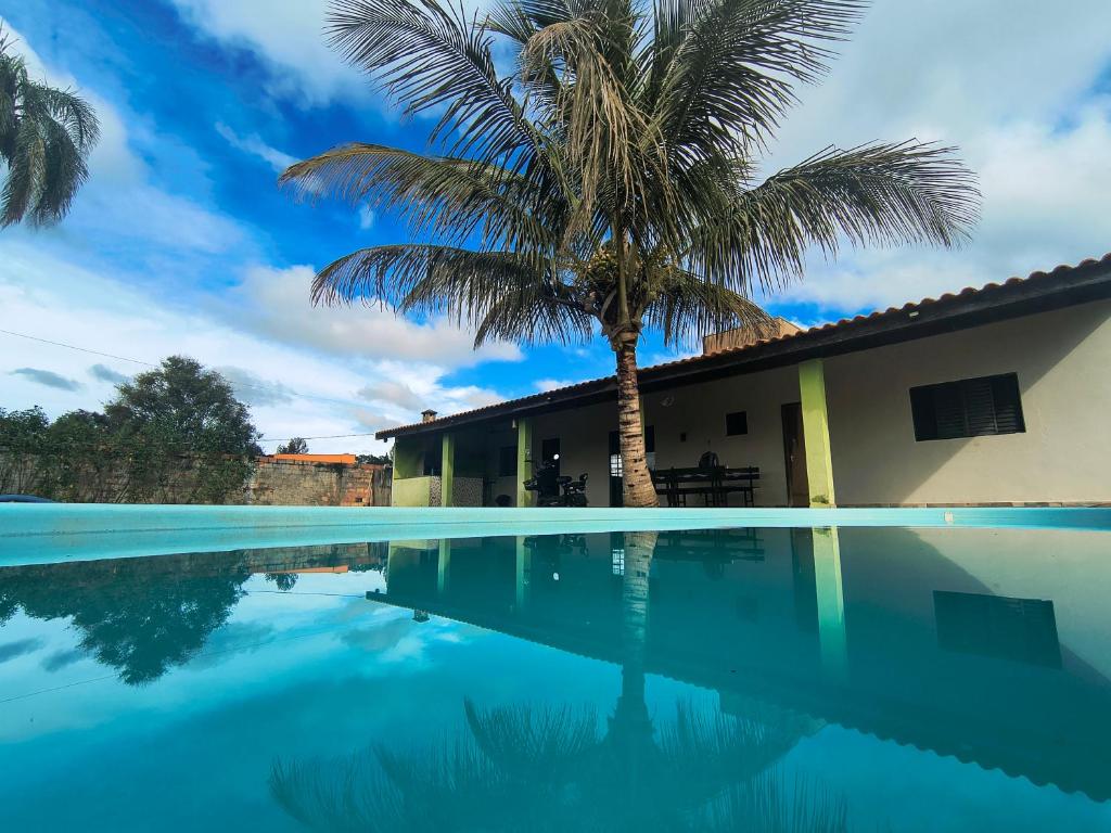 a villa with a palm tree and a swimming pool at Chácara com piscina e lazer em Avaré in Avaré