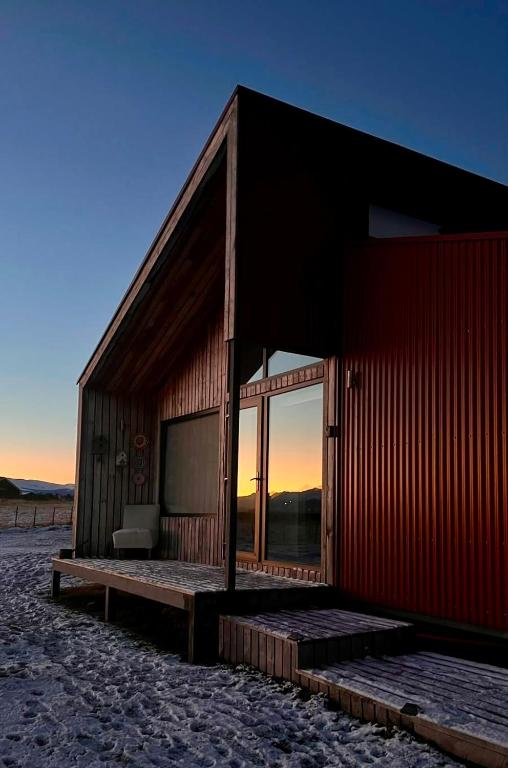 a small house on the beach with the sunset at Cabañas Julián Elías Roja in Puerto Natales
