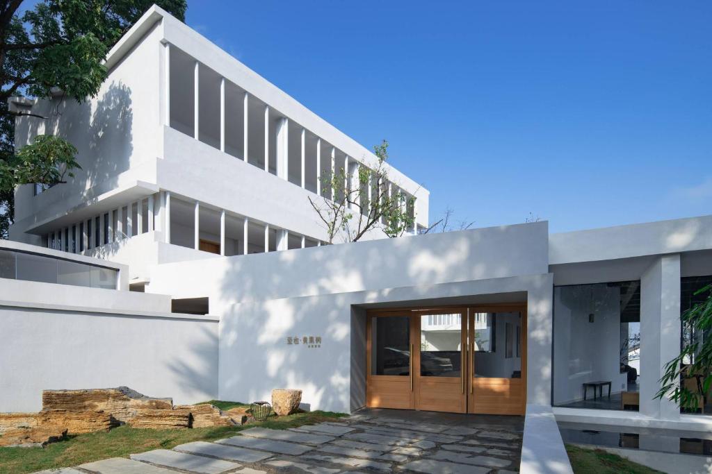 a white house with a wooden door at Zhiye Resort Hotel in Guanling