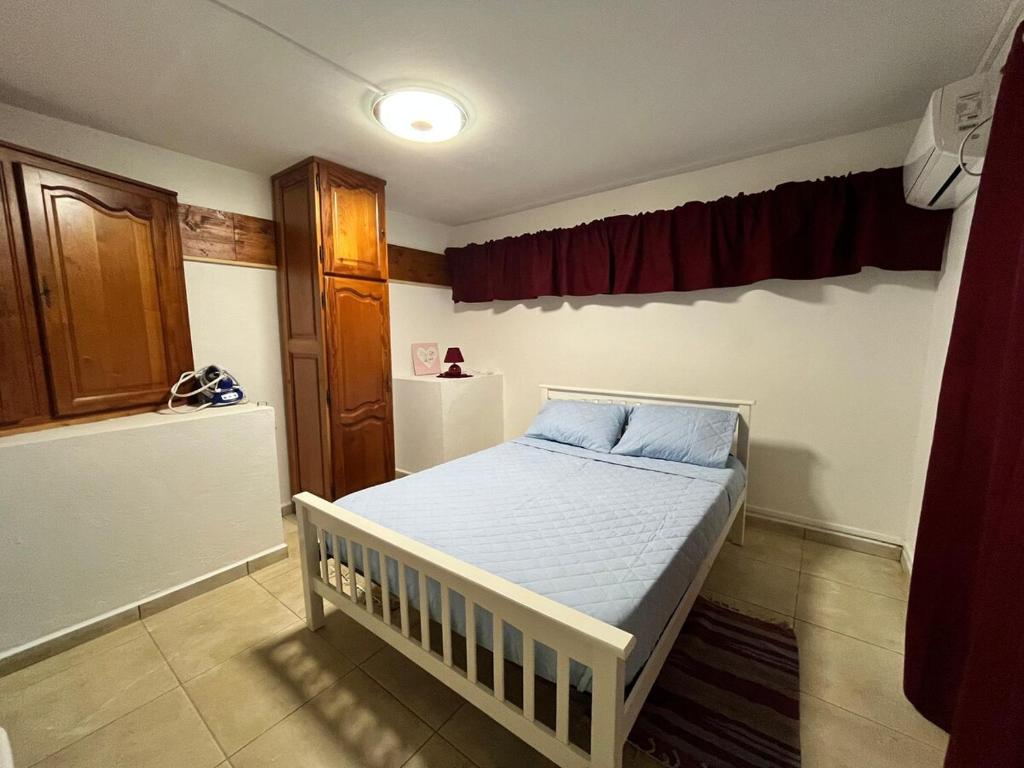 a bedroom with a white bed in a room at Charming house in a natural setting in Sainte-Rose