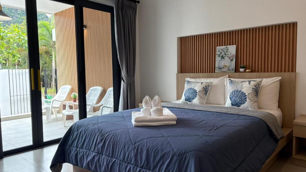 a bedroom with a large bed with a blue comforter at My Home Villa Phangnga in Phangnga
