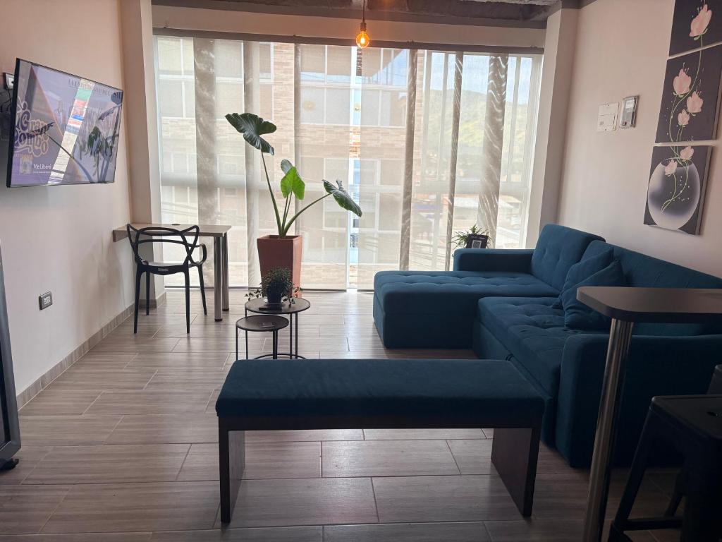 a living room with a blue couch and a table at Villa Celeste Guaduas El Mirador in Guaduas