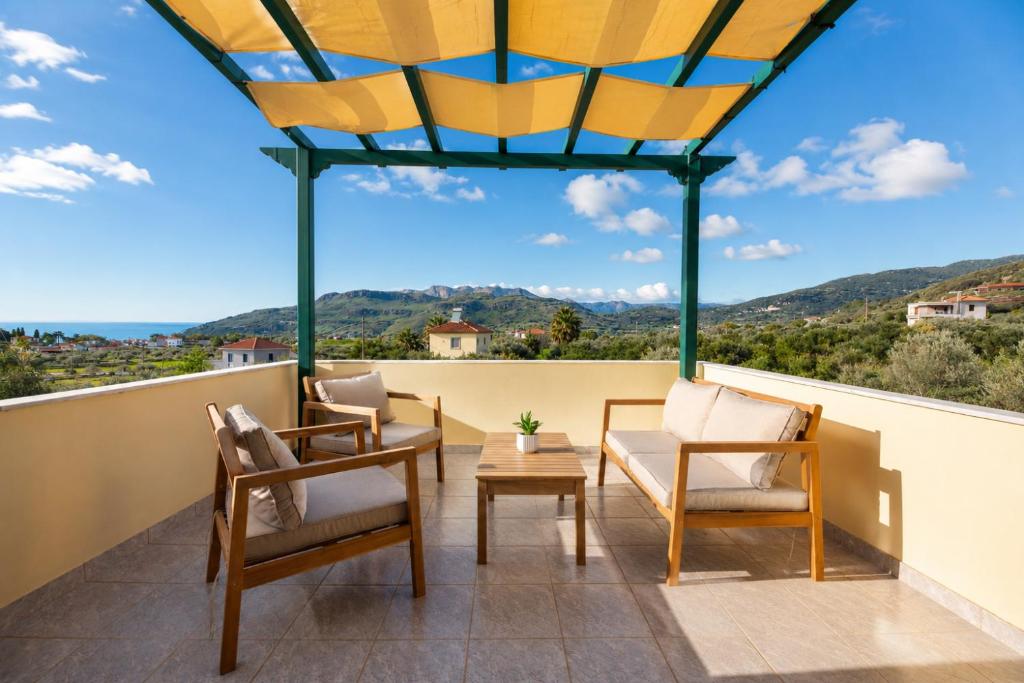 a balcony with chairs and a table and a view at Vasiliki Petri Olive House in Petra