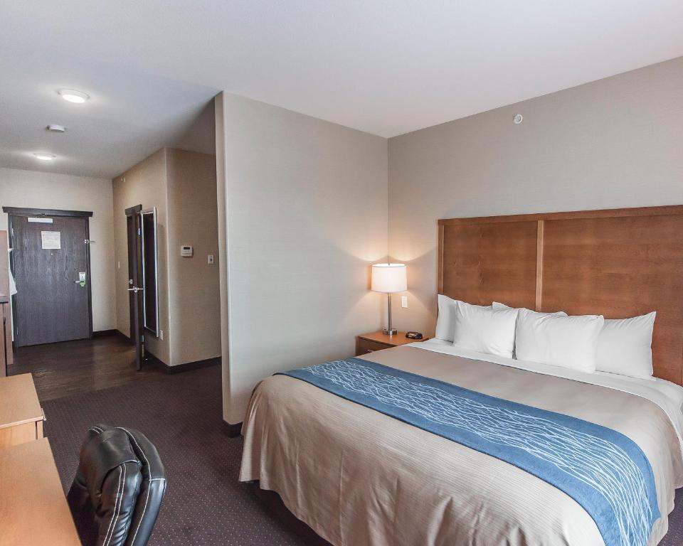 a hotel room with a large bed and a desk at Comfort Inn & Suites Bonnyville in Bonnyville