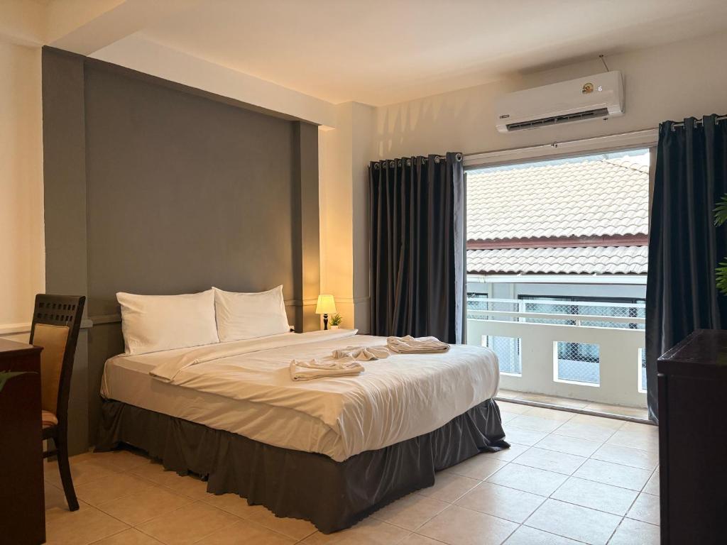 ein Schlafzimmer mit einem Bett und einem großen Fenster in der Unterkunft The LN Hotel in Ko Samui