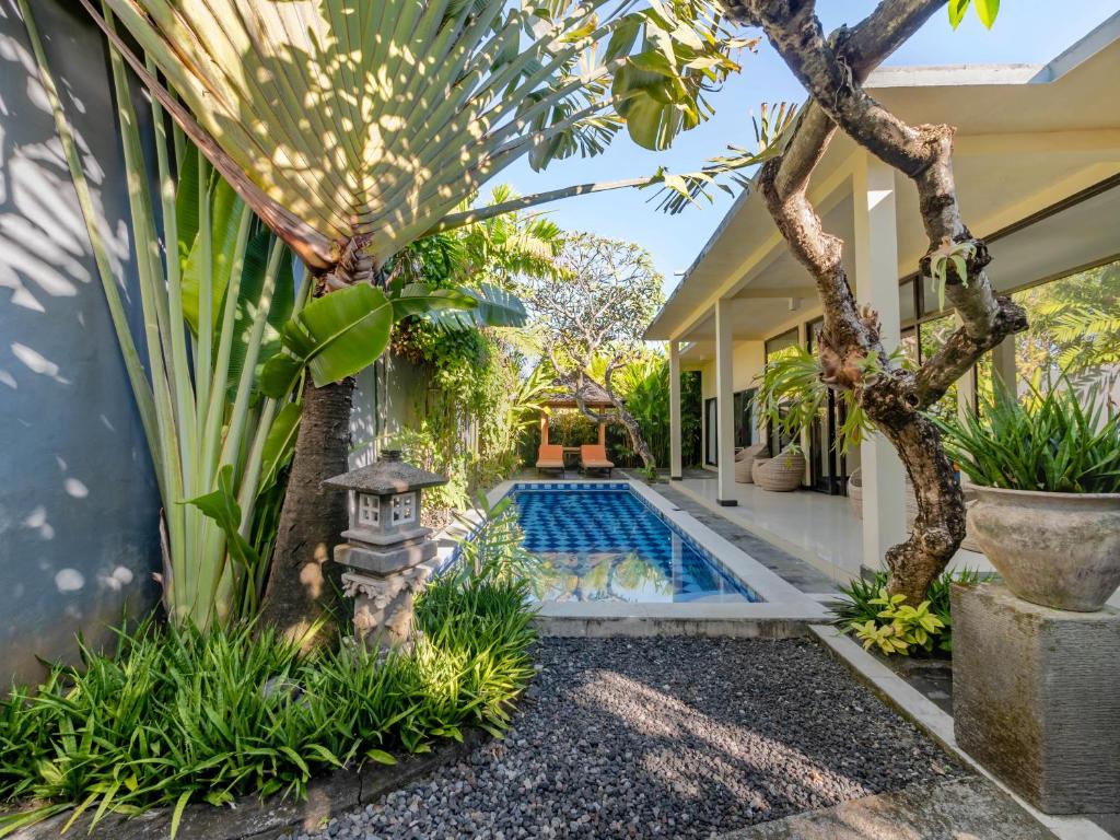 a swimming pool in the middle of a house with plants at Terrace Bali Villa in Nusa Dua