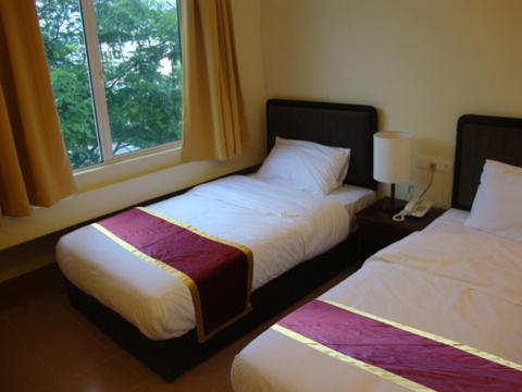 DM Hotel في كوتا كينابالو: سريرين في غرفة مع نافذة