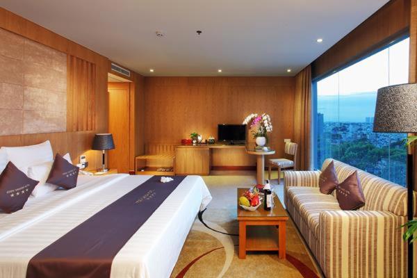 a hotel room with a large bed and a couch at Khu tham quan du lịch in Nam Tu Liem