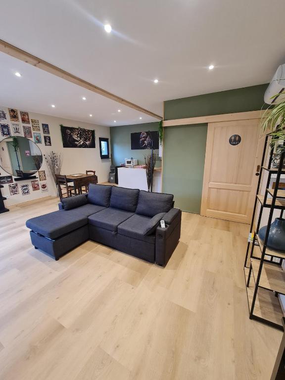 a living room with a blue couch and a table at Tiny House - Studio in Eygurande-et-Gardedeuil