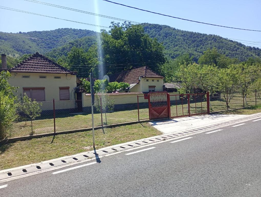 a fence on the side of a road next to a house at Rustic House in Costeşti