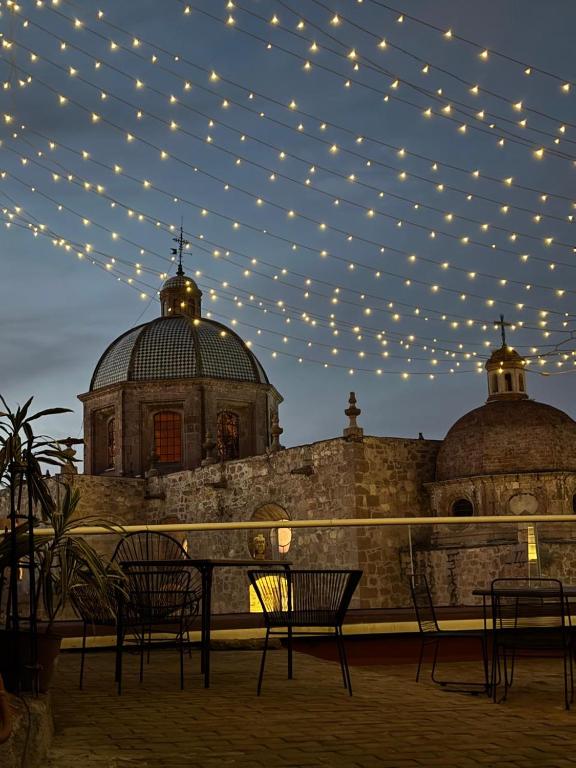 a patio with chairs and lights in front of a building at La Casa Azul Hostal in Morelia