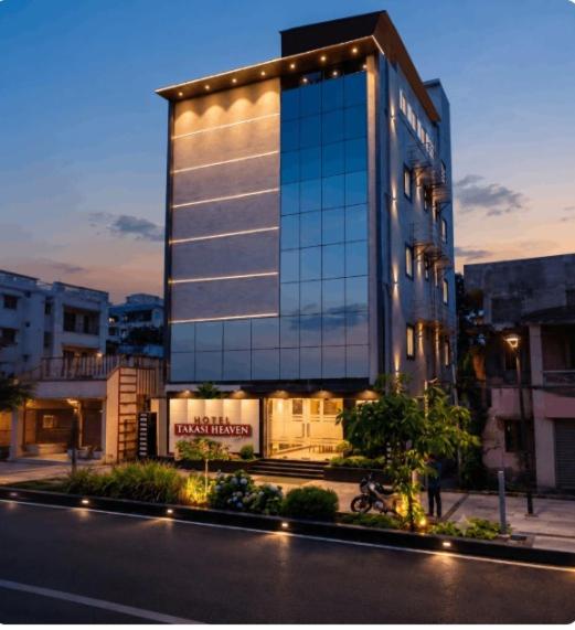 a tall building with lights on the side of a street at Hotel Takasi Heaven in Anakāpalle