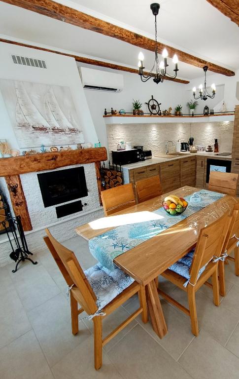 a kitchen with a table and chairs and a fireplace at Holiday House - OLD QUEEN in Šmrika