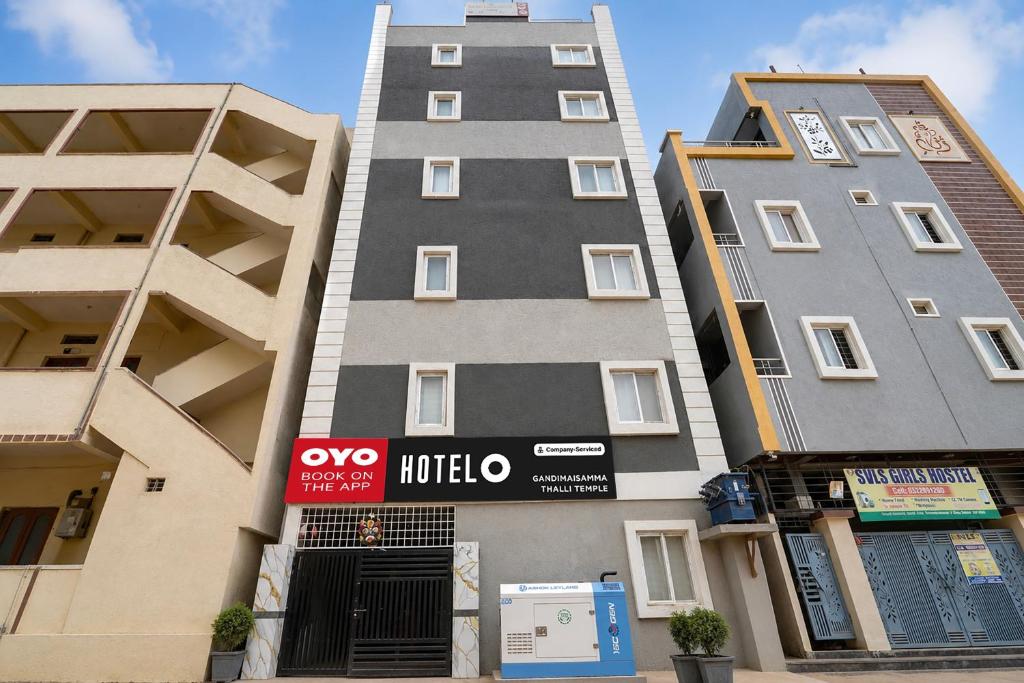a tall building with a sign on the side of it at Super Hotel O Gandimaisamma Thalli Temple Formerly GN Luxury Suits in Dhundgol