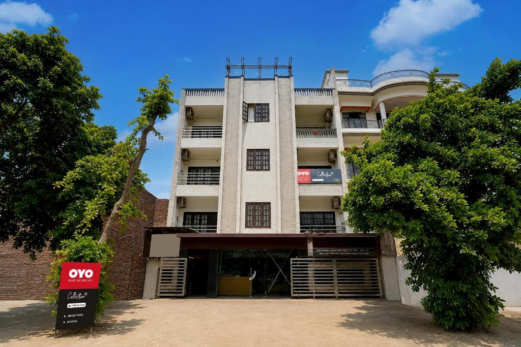 a tall white building with aoc sign in front of it at Collection O Gol Park Atala in Prayagraj